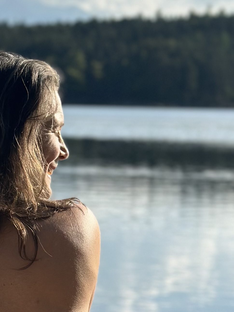 Christina im Profil, ihre Schulter im weichen Licht eines Sees