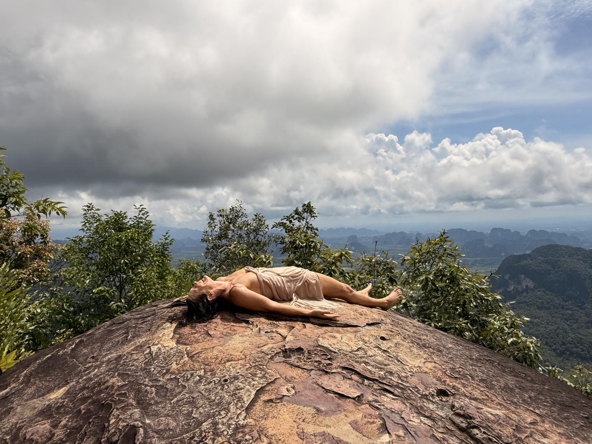 Christina lying stretched out on warm rock under an open sky