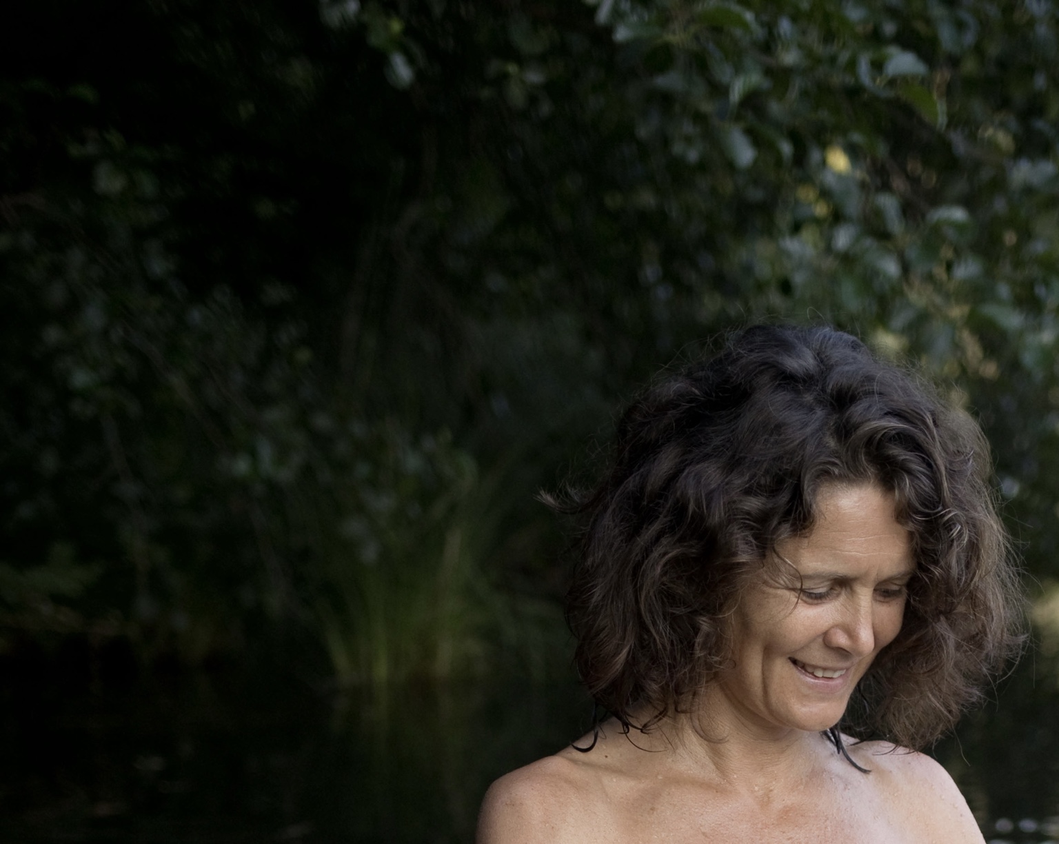 Christina smiling quietly by the water