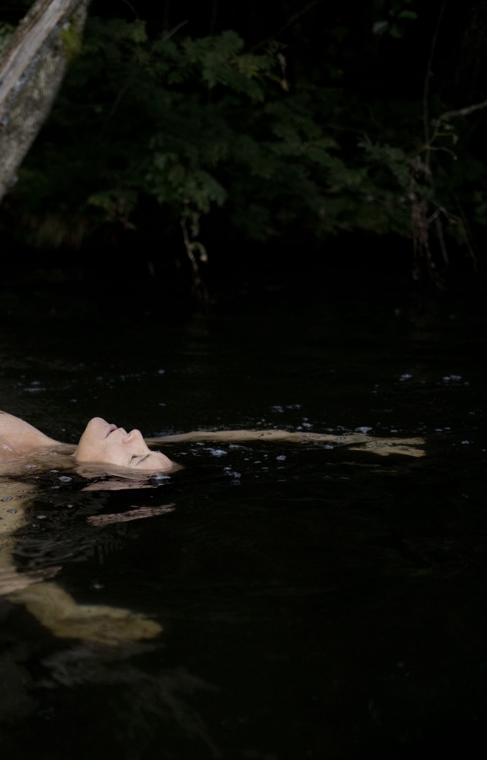 Christina floating still in dark water
